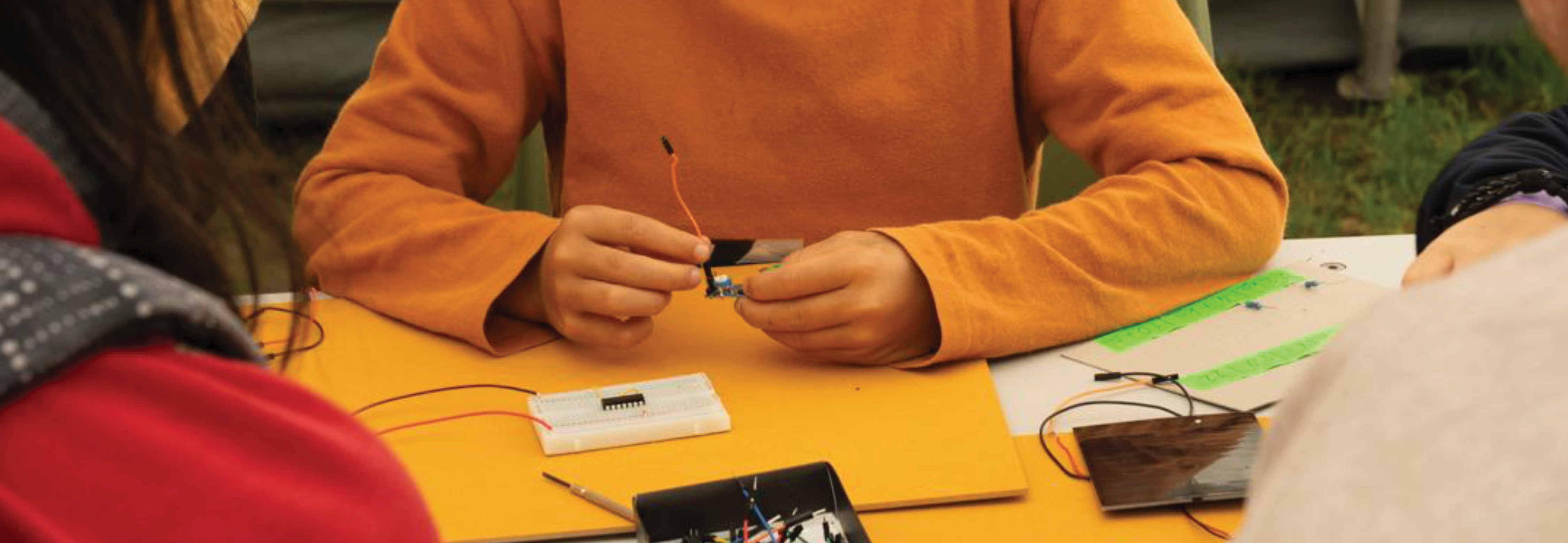 A child assembling an analog circuit on a breadboard